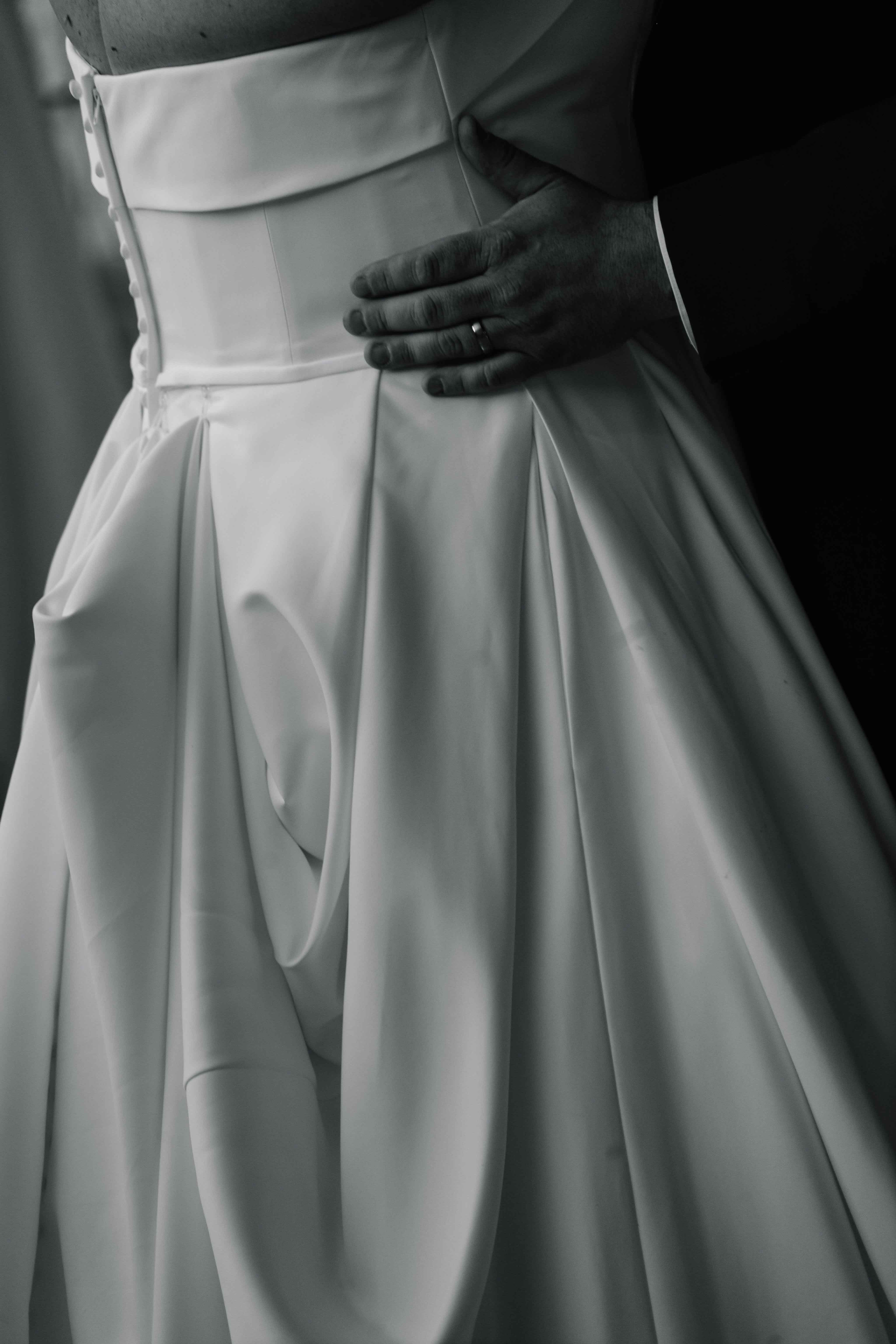 groom with hand around bride's wasist at first dance